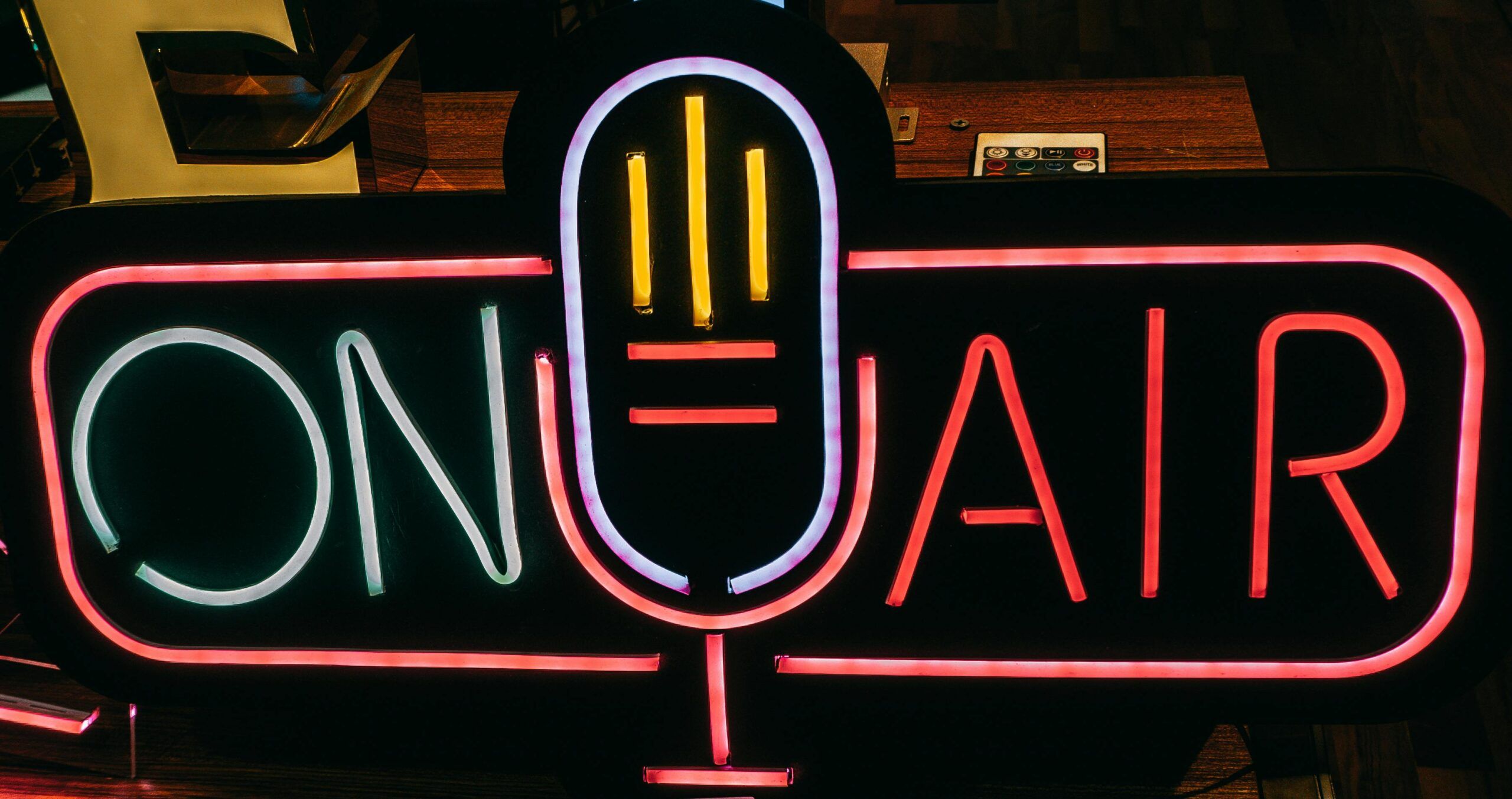 Bright neon 'On Air' sign glowing in a dark studio, perfect for broadcasting themes.