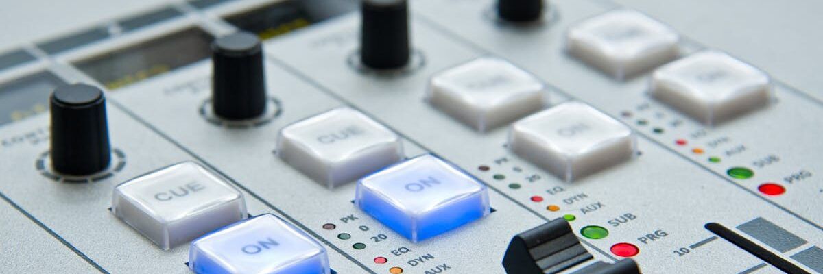 Detailed view of audio mixing console with knobs and buttons for music and sound control.