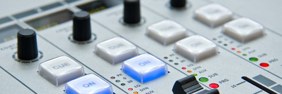 Detailed view of audio mixing console with knobs and buttons for music and sound control.