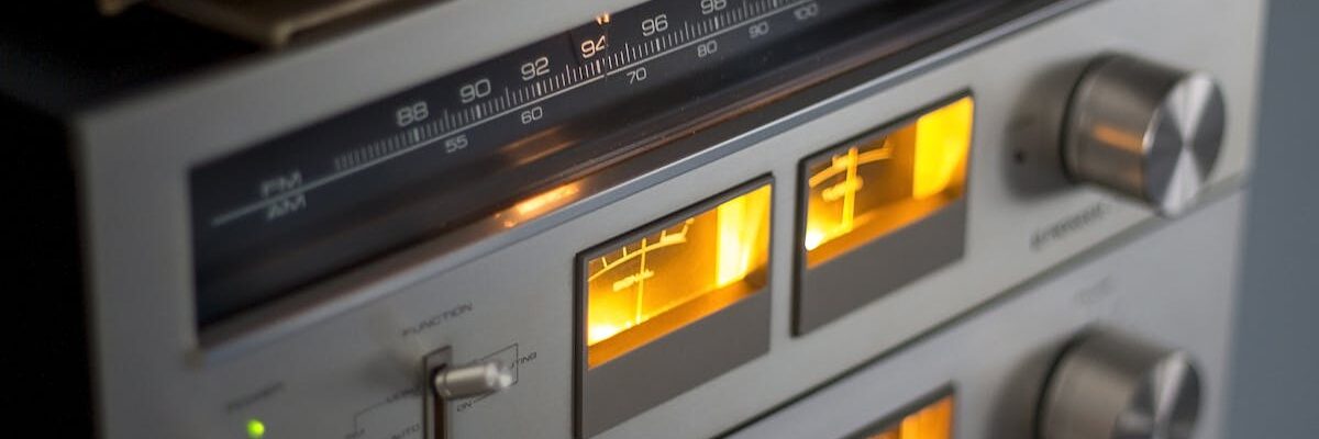 Close-up of retro audio equipment featuring illuminated dials and radio tuner.