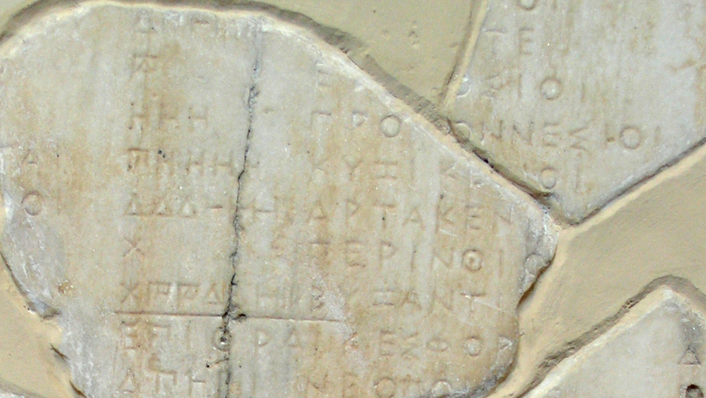 Estela con tributos indicados en numeración ática